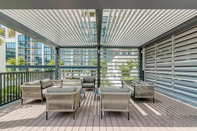 a patio with tables and chairs on a balcony at GlobalStay The Crest Tower C Apartments Dubai in Dubai