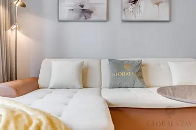 a white couch in a living room with a table at GlobalStay The Crest Tower C Apartments Dubai in Dubai