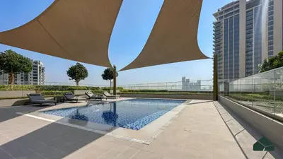 a swimming pool with chairs and a building at Luxurious 2BR with Sea and Burj View by BMS in Dubai