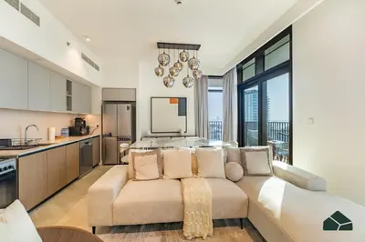 a living room with a couch and a kitchen at Luxurious 2BR with Sea and Burj View by BMS in Dubai