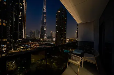 a room with a view of the city at night at Act 2 - Luxury 2BR Facing Burj Khalifa & Fountain in Dubai