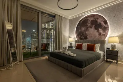a bedroom with a large moon mural on the wall at Cosmic Address 2BR Burj Views above Dubai Mall - By Maxx Value Homes in Dubai