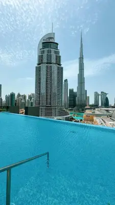 a large swimming pool with a view of a city at Cosmic Address 2BR Burj Views above Dubai Mall - By Maxx Value Homes in Dubai