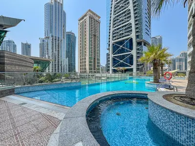 a swimming pool in a city with tall buildings at Modern 1 Bed With Marina Views Near JBR Beach in Dubai