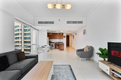 a living room with a couch and a tv at Modern 1 Bed With Marina Views Near JBR Beach in Dubai