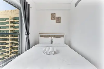 a bedroom with a bed with two white slippers at Modern 1 Bed With Marina Views Near JBR Beach in Dubai