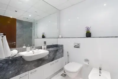 a white bathroom with a sink and a toilet at Bellaviu Holiday Homes,1BR Elegant Stay, Noora Tower, Business Bay in Dubai