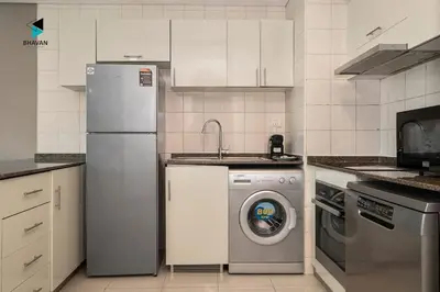a kitchen with a washing machine and a refrigerator at Stylish Stay at Bay Central with Skyline Views in Dubai