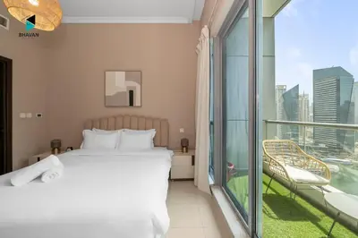 a bedroom with a bed and a balcony at Stylish Stay at Bay Central with Skyline Views in Dubai