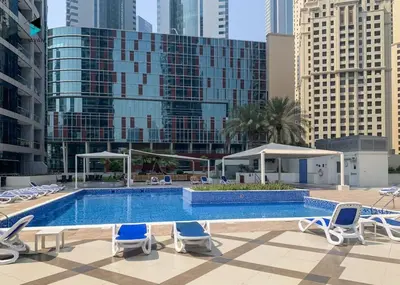 a swimming pool with lounge chairs and a hotel at Stylish Stay at Bay Central with Skyline Views in Dubai