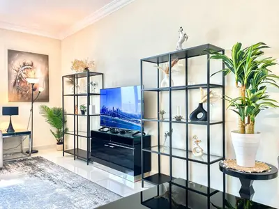 a living room with a tv and a display case at 2 Bedroom Apt in Damac Capital Bay Tower A, Business Bay by Luxaura in Dubai