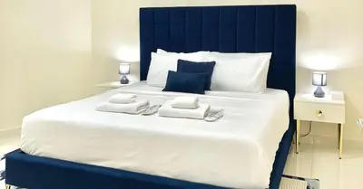 a blue and white bed with towels on it at 2 Bedroom Apt in Damac Capital Bay Tower A, Business Bay by Luxaura in Dubai