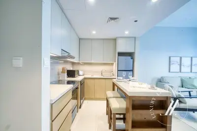 a kitchen and living room with a table and a couch at Luxury 1BR Harbour Views Tower 2 Creek Harbour Dubai in Dubai