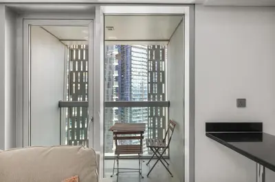 a room with a balcony with a table and a chair at 2BR In The World-Famous Twisted Skyscraper in Dubai