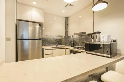 a kitchen with a stainless steel refrigerator and a counter at Premium Central Home with Burj Khalifa View in Dubai