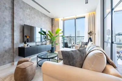 a living room with a couch and a tv at Close to Dubai Miracle Garden, Dubai Autodrome, and Sports City, with JVT Community Park just steps away - The Ivy, Jumeirah Village Triangle by Deluxe Holiday Homes in Dubai