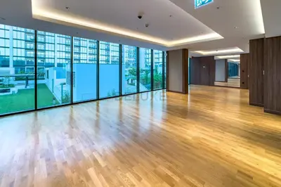 a large room with wooden floors and large windows at High-Floor 2BR with Skyline Views, Steps from a Park, Minutes Drive to Meydan Golf Club and Ras Al Khor Wildlife Sanctuary, Sobha Hartland The Crest Tower C, Sobha Hartland by Deluxe Holiday Homes in Dubai