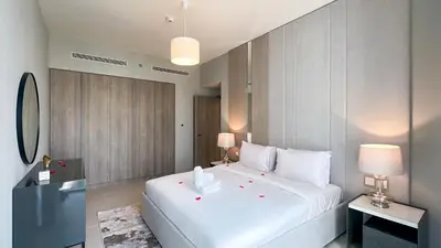 a bedroom with a large white bed and two lamps at Luxury Stay 1BR, Waterfront in Marina LIV Tower - 20AB05 in Dubai