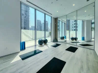 a yoga room with large windows and black mats at Exclusive Marina Lifestyle with Stunning Views in Dubai