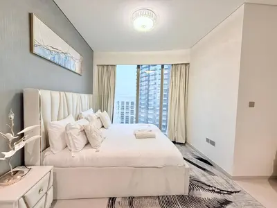 a bedroom with a large white bed with a window at Skyline Escape 2BR with Balcony Pool & Gym in Dubai