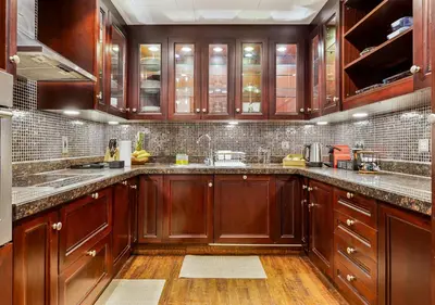 a large kitchen with wooden cabinets and wooden floors at 2BR Downtown Dubai 5 Min Walk to Dubai Mall & Burj in Dubai