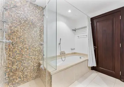 a bathroom with a tub and a glass shower at 2BR Downtown Dubai 5 Min Walk to Dubai Mall & Burj in Dubai