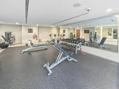 a gym with several tread machines and a mirror at New 1BR with Burj Khalifa Views Near Dubai Mall in Dubai