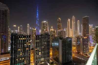 a view of a city skyline at night at New 1BR with Burj Khalifa Views Near Dubai Mall in Dubai