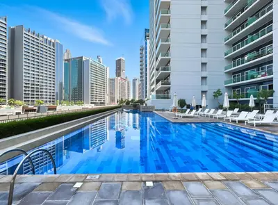 a swimming pool with chairs and a building at New 1BR with Burj Khalifa Views Near Dubai Mall in Dubai