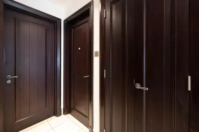 two dark wood doors in a room with a tile floor at Elegant 1-BR in Downtown Dubai's Old Town in Dubai