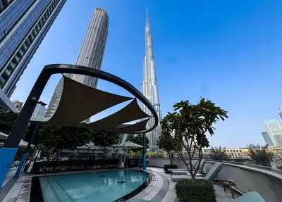 a swimming pool in a city with two tall buildings at Grande Signature 2BR Burj Khalifa & Dubai Fountain in Dubai
