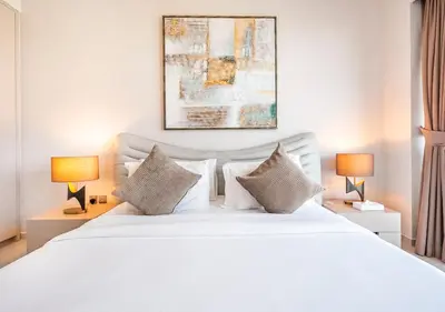 a bedroom with a large white bed with two lamps at Grande Signature 2BR Burj Khalifa & Dubai Fountain in Dubai
