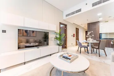 a living room with a large tv and a table at Stunning 1BR with Panoramic Canal Views, Convenient Downtown Access and Walking Distance to Bus Stop, J One - 1, Business Bay by Deluxe Holiday Homes in Dubai