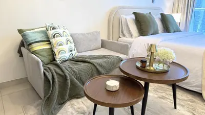 a living room with a couch and two tables at Studio with Amazing Lake Views in Arch Tower, JLT in Dubai