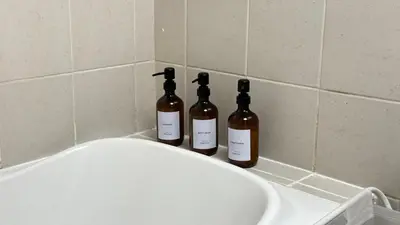 three bottles of wine sitting on top of a sink at Studio with Amazing Lake Views in Arch Tower, JLT in Dubai