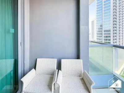 two chairs on a balcony with a view of a city at Luxury 2-Bedroom Apartment, Downtown Skyline Views in Dubai