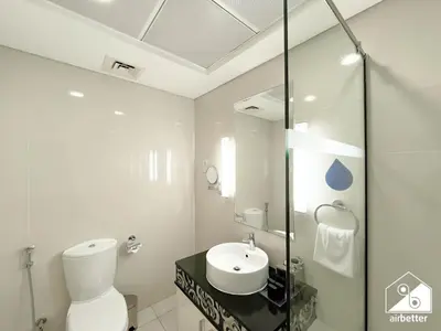 a white bathroom with a toilet and a sink at Luxury 2-Bedroom Apartment, Downtown Skyline Views in Dubai