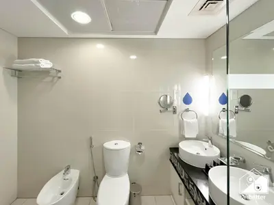 a white bathroom with a toilet and a sink at Luxury 2-Bedroom Apartment, Downtown Skyline Views in Dubai