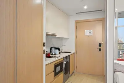 a kitchen with a stove and a door leading into a room at FIRST CLASS Studio Stylish , Prime Location in Dubai