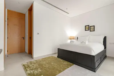 a bedroom with a large white bed and a door at FIRST CLASS 3BR Comfort and Style , Business Bay in Dubai