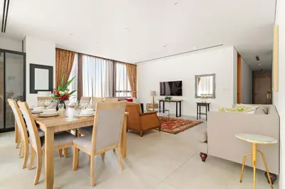 a dining room and living room with a table and chairs at FIRST CLASS 3BR Comfort and Style , Business Bay in Dubai