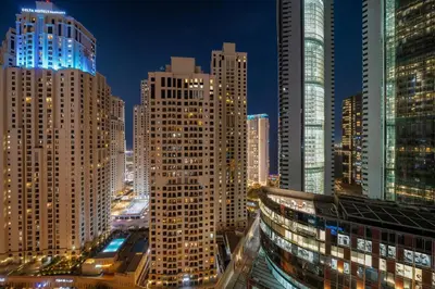 a view of a city at night with tall buildings at FIRST CLASS 1BR Marina Skyline Escape in Dubai