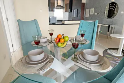 a glass table with a bowl of fruit and wine glasses at FIRST CLASS 1BR Iconic Burj Khalifa View in Dubai