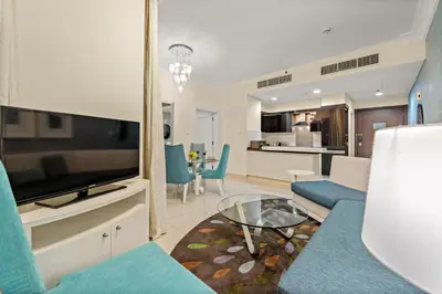 a living room with a flat screen tv and a couch at FIRST CLASS 1BR Iconic Burj Khalifa View in Dubai
