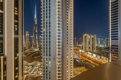 a tall white building in a city at night at FIRST CLASS 1BR Iconic Burj Khalifa View in Dubai