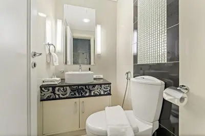 a white bathroom with a sink and a toilet at FIRST CLASS 1BR Iconic Burj Khalifa View in Dubai