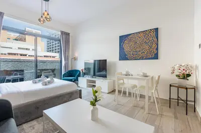 a hotel room with a bed and a living room at Chic Studio in Vibrant Oxford Residence in Dubai