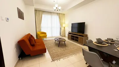 a living room with a couch chair and a television at Stylish 1BR Canal View Apartment Business Bay in Dubai