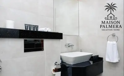 a bathroom with a white sink and a black counter at Park Vista-Infinity Pool View in Dubai
