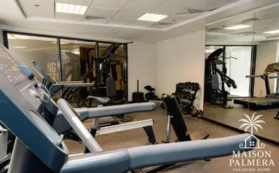 a gym with treadmills and machines in a room at Park Vista-Infinity Pool View in Dubai
